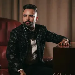 A classic, handsome portrait of the groom seated in a leather chair, looking away thoughtfully. This shot exudes confidence and style.