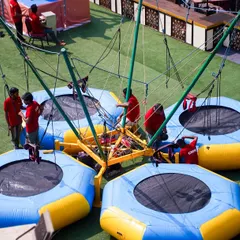 Our four-person bungee trampoline is a major attraction, allowing guests to safely jump, flip, and soar high in the air. It's a fantastic centerpiece for any large outdoor event.