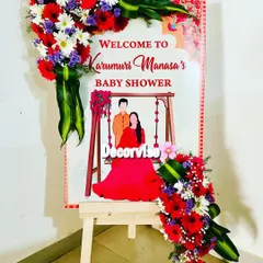 Another example of our custom welcome signs, this one for Manasa's baby shower. We adorned the easel and board with vibrant bouquets of red, white, and purple flowers to match the traditional theme of the event.