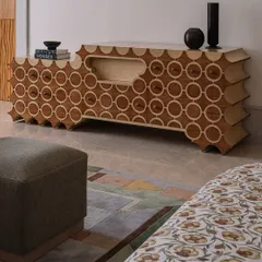 This is 'Brutus,' our handcrafted TV unit. The design features a repeating circular pattern inlaid into the wood, with a unique scalloped profile. It’s a piece that hides technology behind a beautiful, sculptural facade.