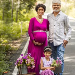 The complete family enjoying a walk before the new baby arrives. This outdoor maternity photo shows the family in a relaxed, natural setting, highlighting their connection and anticipation.