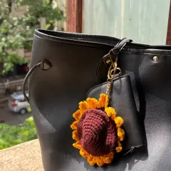 Here is the sunflower coin purse by itself, clipped to a bag. The bright yellow petals and rich brown center are designed to look just like a real sunflower.