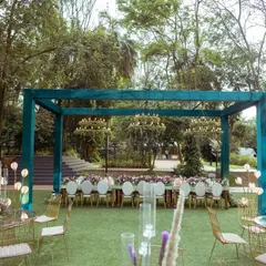A wider perspective of the outdoor dining area, showing the arrangement of tables and the main dining structure against the backdrop of lush trees and the nearby lake.