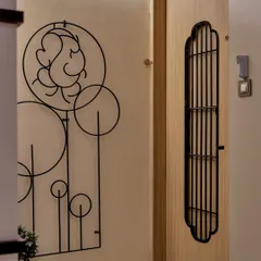 This entryway makes a spiritual and artistic statement. A minimalist metal wall sculpture of Lord Ganesha greets visitors, setting a tone of peace and positivity from the moment they arrive.