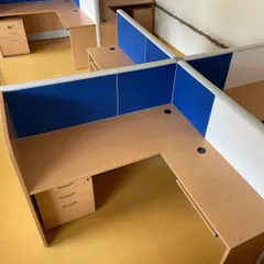 An overhead view of a four-person workstation cluster. These cubicles feature low partitions with fabric panels that offer some privacy and acoustic absorption.