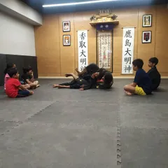 A key part of my teaching method is breaking down complex moves step by step. Here, the class watches closely as I demonstrate a ground control position on one of the students.