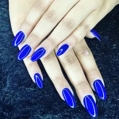 A bold and beautiful statement with a single color. This vibrant, glossy royal blue looks stunning on these perfectly shaped oval nails. Sometimes a flawless application of a striking color is all you need.