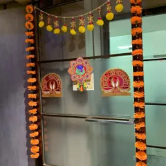Even simple touches can make a big difference. Here is an example of classic Diwali decor for an office entrance, featuring marigold garlands and traditional 'Shubh Labh' signs to welcome employees.