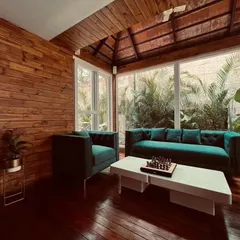 This patio for Mr. Amar Nagaram, founder of Virgio, features rich Brazilian Ipe wood flooring and a traditional Mangalore tile roof. The space is designed as a cozy, elegant retreat that seamlessly blends with the surrounding nature.
