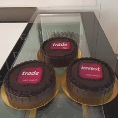 For large corporate events, I can create multiple cakes with consistent branding. This order for Axis Direct features their different service logos on rich chocolate cakes, perfect for a multi-team celebration or brand activation.