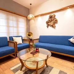 I believe furniture should bring people together. This living room set, featuring a 5-seater teak wood sofa and armchairs with vibrant blue upholstery and rattan details, was crafted to create a space that is both elegant and incredibly inviting.