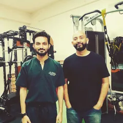 A happy client stands with Dr. Naman after a successful treatment journey. Seeing our patients regain their health and well being is the most rewarding part of what we do.