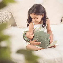 A beautiful moment of connection. We gently guide older siblings to interact with the new baby to capture these authentic, heartwarming photos.