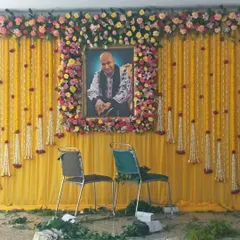A classic and simple backdrop for a home gathering. I used a bright yellow curtain and decorated it with hanging garlands of marigolds and rajnigandha, with a floral frame for Guru Ji's portrait.