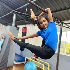 The aura of a champion. This student demonstrates incredible flexibility and strength, holding a perfect split on the bar. This is the result of serious dedication.
