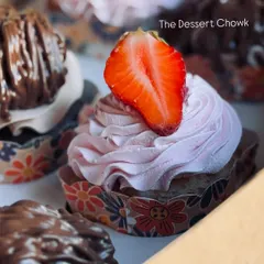 A close-up of my Strawberry Fresh Cream cupcake. It's a light, vanilla-based cupcake topped with a swirl of fresh strawberry cream and a slice of strawberry.