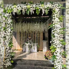 We believe a beautiful beginning sets the tone for the entire event. This grand entrance arch, crafted with a dense arrangement of white carnations, roses, and hanging wisteria, provides an elegant and memorable welcome for your guests.