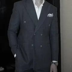 The double-breasted suit projects confidence and authority. This grey checked version, tailored for a client, showcases our ability to create a modern fit while honoring a classic design.
