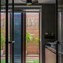 A bold take on modern luxury, this bathroom opens up to a private green courtyard. The design connects the indoor shower space with the outdoors, enhancing the feeling of a natural, open-air retreat.