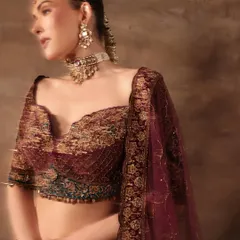 A close-up on the craftsmanship I prioritize. This deep wine-colored blouse features intricate zardozi and threadwork, paired with a statement choker and matha patti for a complete, regal bridal look.