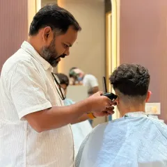 Another shot of a men's haircut in progress. We use both clippers and scissors to achieve the perfect fade and shape.
