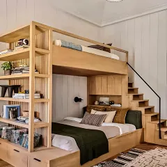 This custom bunk bed is a complete bedroom solution, with a built-in staircase that has storage drawers, and an integrated full-wall bookshelf. The natural wood finish gives it a timeless, sturdy feel.