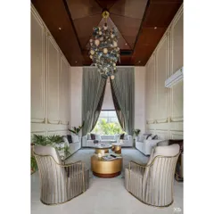 A closer look at the living room's details, showing the custom wall paneling and elegant armchairs. The design focuses on creating a sophisticated yet comfortable atmosphere for a well-traveled family.