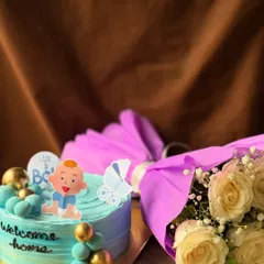 A "Welcome Home" gift set for a new baby boy, including a custom cake and a beautiful bouquet of fresh flowers.