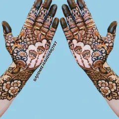 A beautiful back-hand design featuring delicate jharokha (balcony) motifs and peacocks. The fingers are fully covered in henna, a traditional practice for brides, and the patterns are fine and symmetrical.