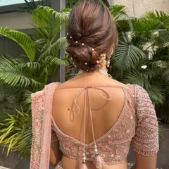 A close-up of the pearl-adorned textured bun. This style is perfect for a bride wearing a pastel lehenga, as it adds a touch of sophistication and romance.