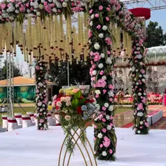 A beautiful outdoor mandap decorated with pillars of pink and white flowers and a ceiling of hanging jasmine strings (mogra).