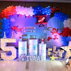 An airplane themed 5th birthday party we catered for. The decor, from the backdrop to the light-up numbers, was all designed to create a fun 'fly high' experience.