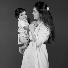 A mother gazes lovingly at her smiling baby. These black and white portraits emphasize emotion and connection, creating a powerful and intimate image.
