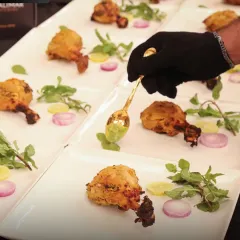 Every detail matters to us. Here, one of our staff members adds the final touch of green chutney to a tandoori chicken starter, showcasing the precision and care we put into every single plate.