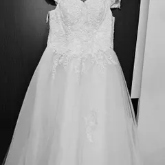 This is a classic white ball gown, perfect for a pre-wedding shoot or to feel like a princess. It features an off-shoulder neckline and delicate lace applique on the bodice and skirt.