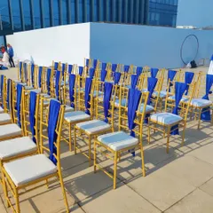 A closer look at the seating for the Indigo Airlines event. We used gold Chiavari chairs with white cushions and elegant blue sashes, perfectly matching the airline's corporate colors for a cohesive and branded look.