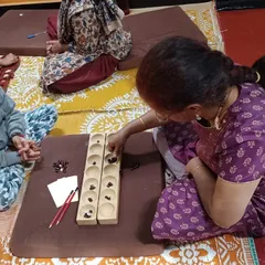 A participant in our "Khel Khel Mein" workshop playing Palanguzi, a traditional board game, learning how to merge timeless games with curriculum subjects.