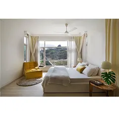 I believe in the power of simplicity to create calm. This minimalist bedroom is designed as a serene sanctuary, using a clean white palette and large windows that frame the natural landscape, proving that sustainable design can be both modern and tranquil.