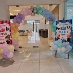 A beautiful pastel rainbow balloon arch creating a grand entrance for a Boss Baby themed party.