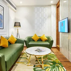 This hotel lounge area uses a bold color palette with green leather sofas and yellow accents to create an energetic yet refined atmosphere. The design includes custom paneling and abstract art to elevate the guest experience.