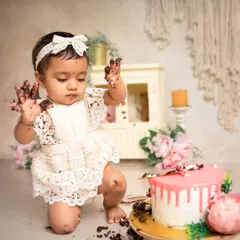 Look at those messy hands. This little one is having the time of her life during her first birthday cake smash, a moment of pure, chaotic joy.