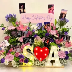 For Valentine's Day, I create bespoke floral arrangements that go beyond the ordinary. This one features a sea of flowers, personalized photos, and light-up initials for a truly unique declaration of love.