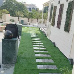 A clean and modern look for this terrace walkway, created by laying artificial grass with stone slab pavers.