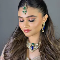 A close-up of the bride with her eyes closed, showing the beautiful pink and gold eyeshadow. This look is perfect for a North Indian wedding ceremony.