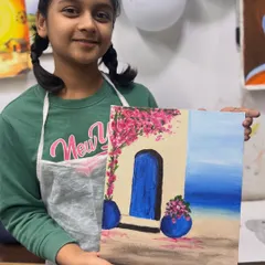 This young artist is so proud of her Greece-themed painting, complete with a vibrant blue door and blooming bougainvillea. A beautiful result from our kids' workshop.