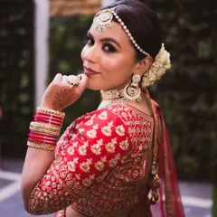 A beautiful back-shot of the bride, showing the details of her blouse and hairstyle. The makeup from this angle highlights her glowing skin and the perfect harmony between her look and her outfit.