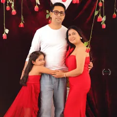 A classic family portrait with a Valentine's theme. The whole family is dressed in red and white, creating a coordinated and loving image.
