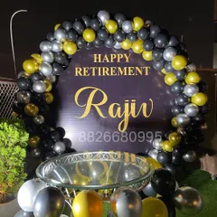 This angle shows how the retirement decoration integrates with other party elements, like a cake table. The loose balloons on the floor add to the festive atmosphere.