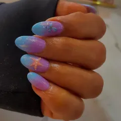 A dreamy mermaid-inspired ombré effect. These almond nails feature a beautiful gradient of purple and blue, with delicate starfish and butterfly art.
