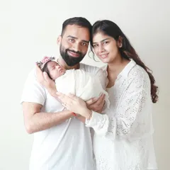 The joy of new parenthood. This couple is beaming with happiness as they hold their precious newborn baby for their first family portrait.